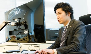 事務所のデスクトップパソコンでリモート通話を行っている写真
